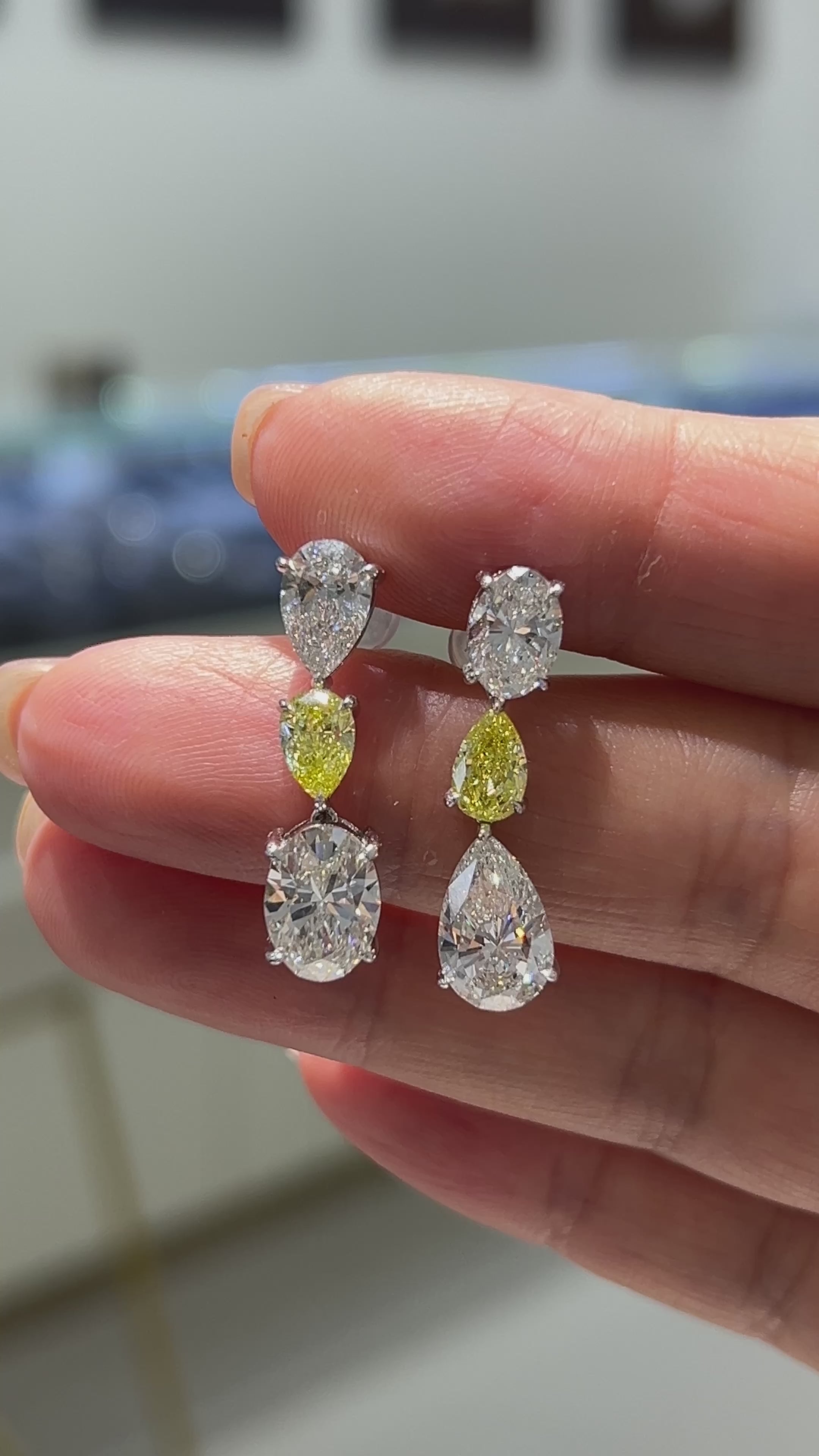 18K gold oval teardrop-shaped stud earrings featuring white and yellow diamonds.