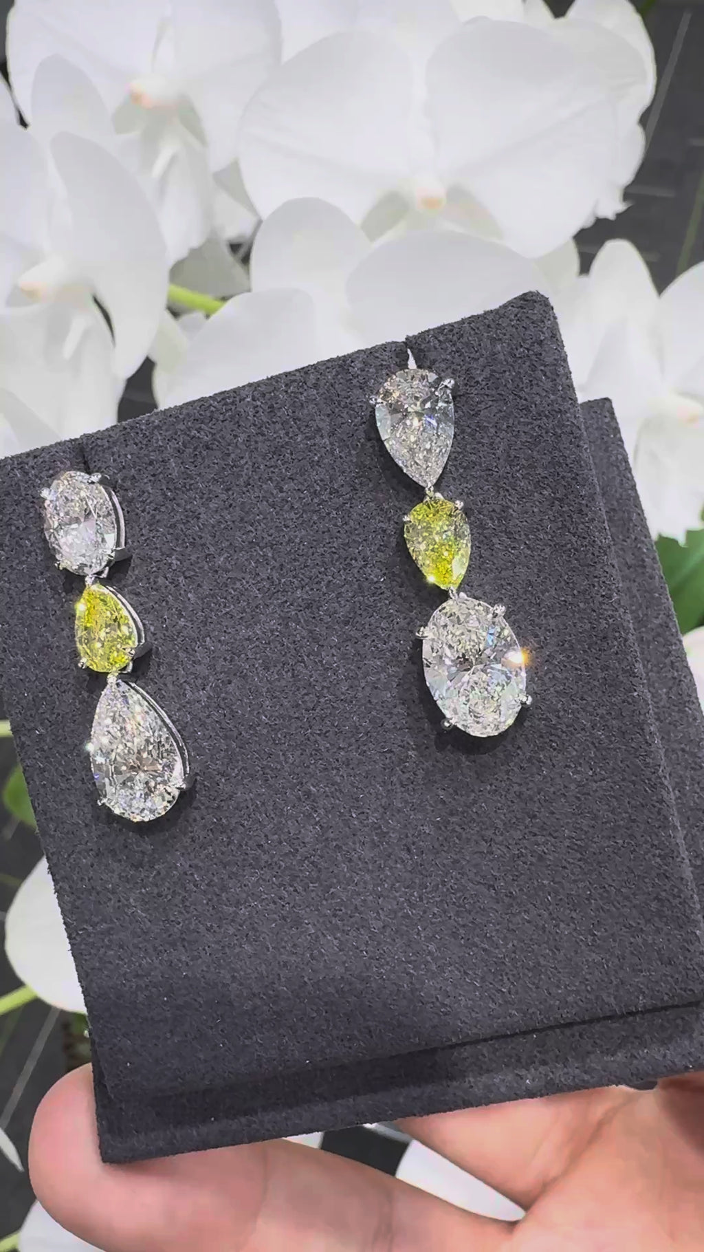 18K gold oval teardrop-shaped stud earrings featuring white and yellow diamonds.